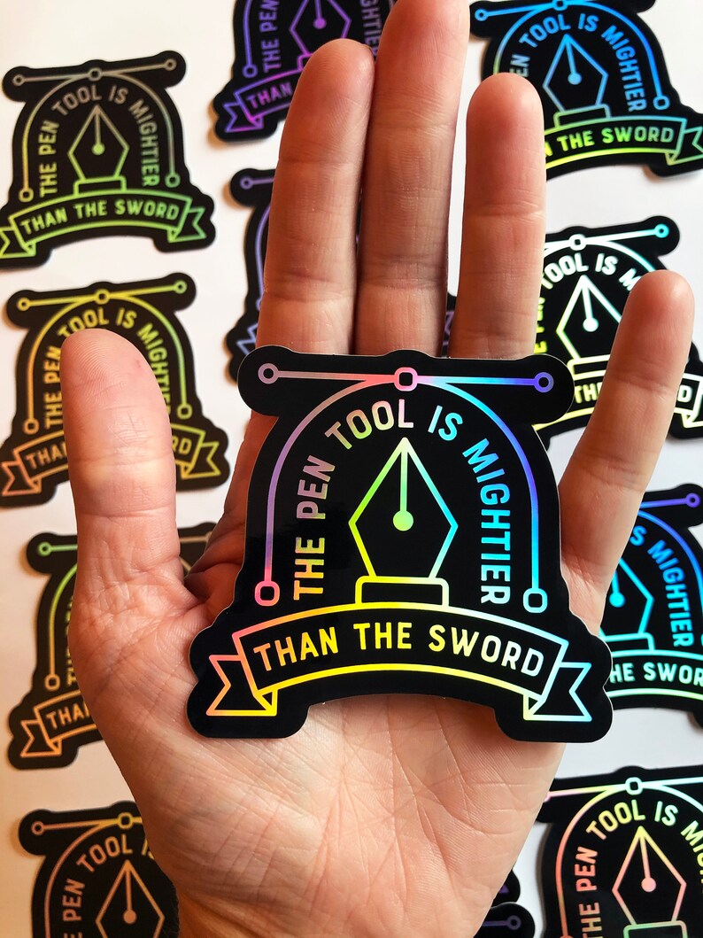 Puede incluir: Una pegatina negra e iridiscente con el texto "The Pen Tool is Mightier Than The Sword" en un degradado arco&iacute;ris. La pegatina presenta un icono de herramienta de pluma estilizado con un c&iacute;rculo alrededor.