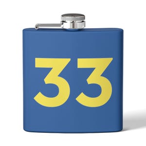 May include: A square-shaped blue metal flask featuring the number 33 printed in large yellow font on the front. The flask has a silver-colored screw-top cap with a hinged arm mechanism attached to the top center of the container.