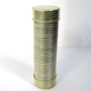 May include: A clear plastic tube filled with a stack of silver coins. The tube has a clear cap and base, and the coins are neatly stacked inside. The coins appear to be of the same size and design.