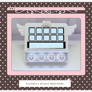 May include: A white stream deck controller featuring ten square buttons, a horizontal display screen, and four circular knobs with character faces. The device is adorned with white angel wings on the sides, a bow at the top, and text reading hachiware stream deck knobs.