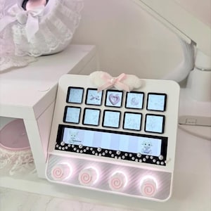 Peut inclure: Un pav&eacute; num&eacute;rique &eacute;lectronique blanc dot&eacute; de dix touches carr&eacute;es avec des &eacute;crans &agrave; motifs bleu clair, un &eacute;cran horizontal affichant deux petits animaux et quatre boutons circulaires &agrave; spirales roses &eacute;clair&eacute;s par une lumi&egrave;re blanche.
