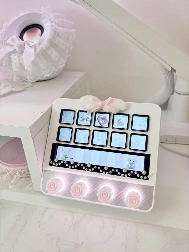 Peut inclure: Un pav&eacute; num&eacute;rique &eacute;lectronique blanc dot&eacute; de dix touches carr&eacute;es avec des &eacute;crans &agrave; motifs bleu clair, un &eacute;cran horizontal affichant deux petits animaux et quatre boutons circulaires &agrave; spirales roses &eacute;clair&eacute;s par une lumi&egrave;re blanche.