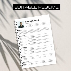 May include: A white resume template with the text "EDITABLE RESUME" at the top. The resume includes sections for "About Me," "Education," "Experience," "Skills," and "References." The resume is spiral-bound.