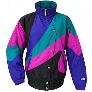 May include: A color-blocked jacket featuring a high collar, a front zipper, and a snap-button closure. The design incorporates diagonal panels of purple, teal, magenta, and black. The word "neve" is printed in white on the lower left sleeve.