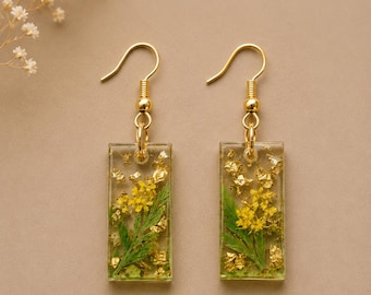 Bloom of Faith Earrings" — it captures the rich red color and delicate floral beauty Handcrafted with real pressed flowers Encased n resin.