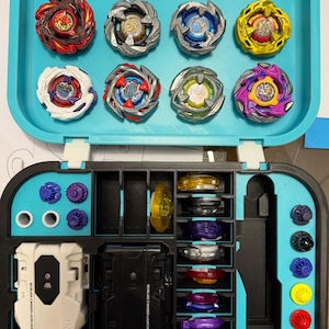 May include: A teal carrying case filled with colorful spinning tops. The case is open, revealing multiple tops in various designs and colors, along with launchers and accessories. The text "BEYBLADE X" is visible.