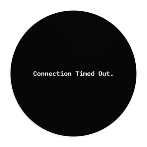May include: A circular black mouse pad featuring the white text Connection Timed Out. centered in the middle. The design is simple and monochromatic, with the text displayed in a clean, sans-serif font against the solid black background.