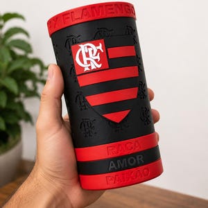 May include: A black and red cylindrical container with the text "FLAMENGO" on the rim. The container features the Flamengo team logo and the words "RACA AMOR PAIXAO".