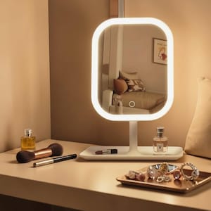 May include: A rectangular vanity mirror with a white frame and integrated LED lighting, mounted on a stand with a built-in white tray base. The mirror features a touch-sensitive power button on the glass surface, reflecting a room interior.