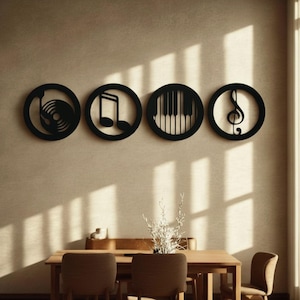 Può includere: Quattro opere d'arte da parete circolari nere a tema musicale. I disegni includono un disco in vinile, una nota musicale, i tasti del pianoforte e una chiave di violino. L'arte è montata su una parete beige sopra un tavolo da pranzo in legno.