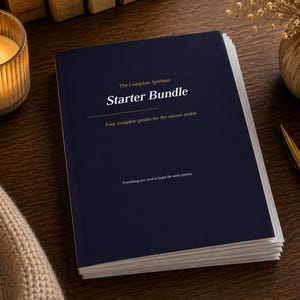 May include: A navy blue "Starter Bundle" book with white text, including the phrases "The Complete Spiritual" and "Four complete guides for the sincere seeker." A lit candle, a gold pen, and a vase of dried flowers are also visible.