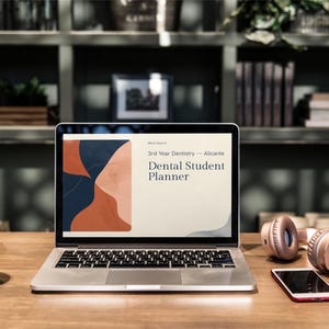 Peut inclure: Un ordinateur portable affiche un "Dental Student Planner" sur son écran, posé sur un bureau en bois, à côté d'une tasse à café, d'un casque et d'un smartphone. L'écran affiche un design avec des formes abstraites dans des tons de bleu, orange et beige. Le texte "3rd Year Dentistry - Alicante" est visible.