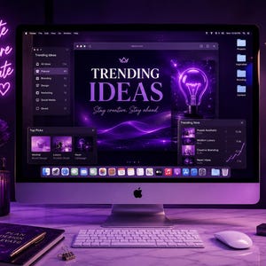 May include: A desktop computer displays "TRENDING IDEAS" with a lightbulb graphic. The desk includes a keyboard, mouse, notebook, and a mug that says "FOCUS CREATE SUCCEER". A neon sign reads "Create Inspire Elevate".