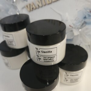 May include: A collection of white jars with black lids containing 2oz whipped beef tallow moisturiser. Each jar features a white label with the text Vanilla and 2oz whipped beef tallow moisturiser, accompanied by a small palm tree graphic icon.