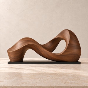 Puede incluir: Una escultura de madera marrón que presenta una forma fluida y continua de onda con un bucle abierto central. La escultura está montada sobre una base negra rectangular y plana, mostrando una superficie pulida con vetas de madera visibles.