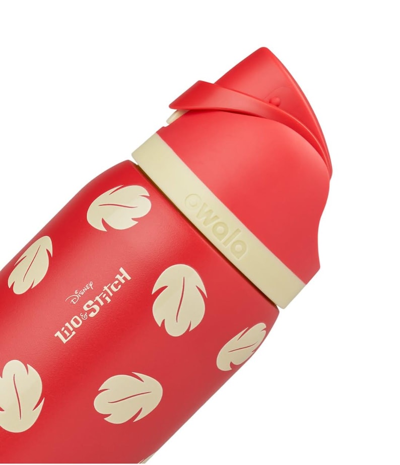 May include: Red Owala water bottle featuring a design inspired by Disney's Lilo & Stitch. The bottle has a red body with cream-colored leaf patterns and a cream-colored band. The text "Disney Lilo & Stitch" is printed on the bottle.