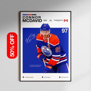 May include: A framed poster of Connor McDavid in an Edmonton Oilers hockey jersey. The jersey is blue and orange with the number 97. The poster includes McDavid's signature, team details, and a motivational quote. A 50% off sticker is on the left.