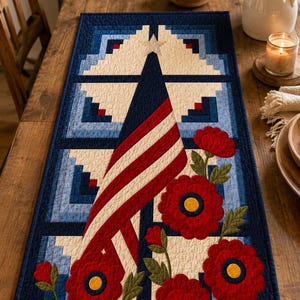 May include: A rectangular quilted table runner featuring a geometric log cabin pattern in shades of navy blue, light blue, and cream. The design includes a central American flag motif and several large red flowers with yellow centres and green leaves.