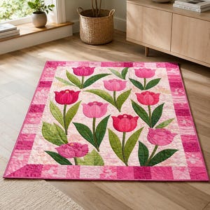 May include: A rectangular quilt featuring a repeating pattern of pink and magenta tulips with green leaves on a light pink background. The quilt is framed by a border composed of alternating dark pink and light pink square fabric patches.