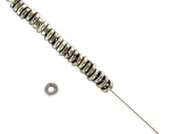 May include: A silver jump ring chain with a single jump ring at the end. The chain is made of many small, connected rings.