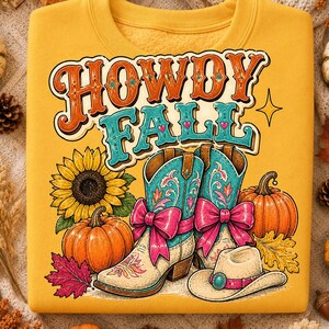 Puede incluir: Una sudadera color amarillo mostaza con un estampado gráfico que dice "HOWDY FALL" en naranja y turquesa. El diseño incluye un girasol, dos calabazas naranjas, un par de botas vaqueras turquesas con lazos rosas y un sombrero vaquero beige.