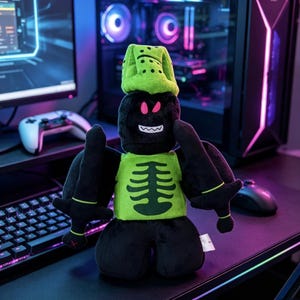 May include: A plush toy featuring a black character with a lime green helmet and a matching chest piece displaying a dark green ribcage graphic. The character has bright pink eyes, a white jagged mouth, and holds two black swords in its hands.