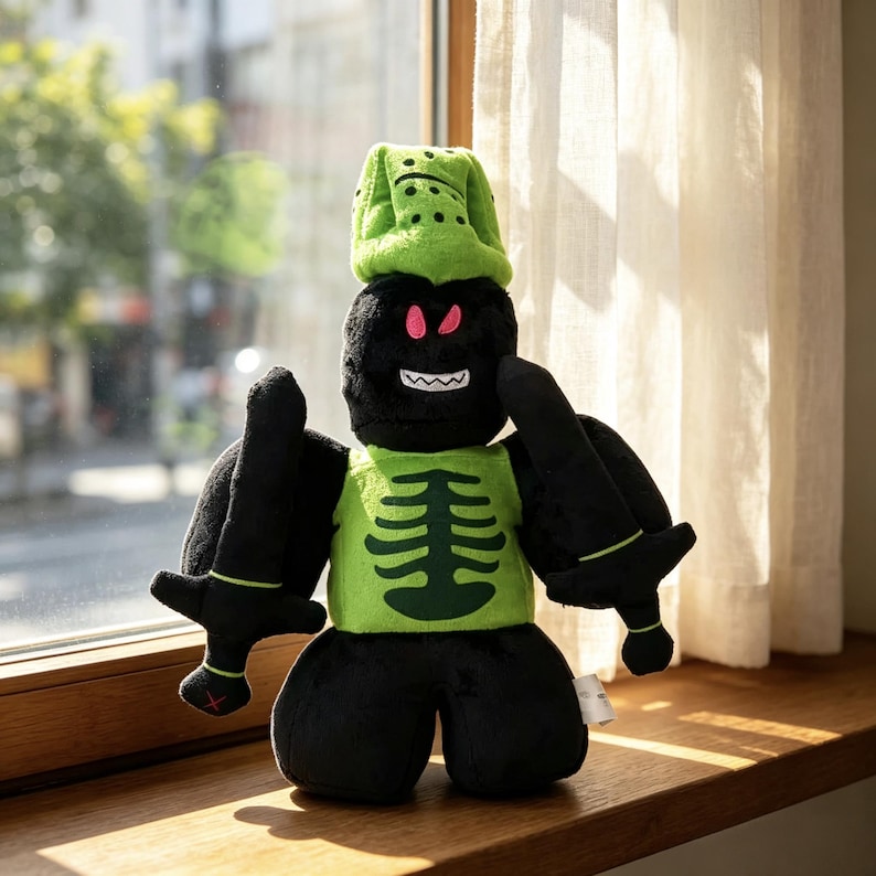May include: A plush toy featuring a black character with a green helmet, a green chest piece with a dark green ribcage graphic, and black pants. The character has pink eyes, a white jagged mouth, and holds a black sword in each hand.