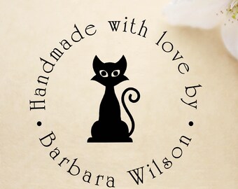 May include: A black cat silhouette sits centered within a circular design. The words "Handmade with love by Barbara Wilson" are arranged around the cat. The design is on a cream-colored background.