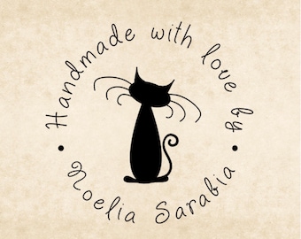 May include: A black cat silhouette with long whiskers is centered within a circular design. The words "Handmade with love by Noelia Sarabia" are written in a cursive font around the cat. The background is a light tan color.