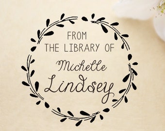 May include: Black and white stamp with a floral wreath design. The text reads "From the Library of Michelle Lindsey".