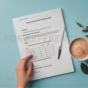 Può includere: Un documento bianco intitolato "Daily Business Admin Checklist SOP" con un elenco di controllo e una penna. Una tazza di caffè è a destra. Il documento è su una superficie azzurra. Il testo "FOR REFERENCE" è parzialmente visibile.