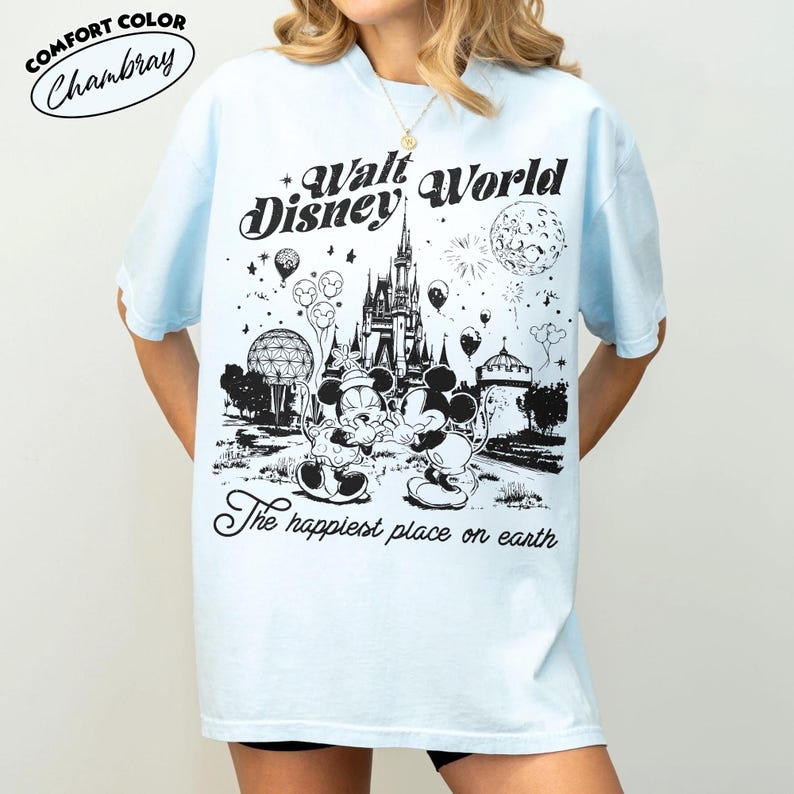 May include: Light blue t-shirt with a black and white graphic of Mickey and Minnie Mouse in front of Cinderella's castle at Walt Disney World. Text includes "Walt Disney World" and "The happiest place on earth."
