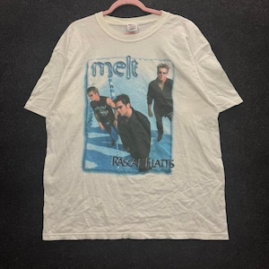 Könnte beinhalten: Ein weißes Kurzarm-T-Shirt mit einem Grafikdruck der Band Rascal Flatts. Das Design enthält den Text melt und Rascal Flatts sowie ein Foto von drei Bandmitgliedern vor einem abstrakten blau-weißen Hintergrund.