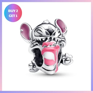A silver charm in the shape of a cartoon character with a pink tongue sticking out, sitting on its hind legs.