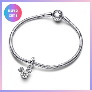 a silver-toned charm bracelet with a charm featuring a Mickey Mouse design, and a tag that says "BUY 2 GET 1".