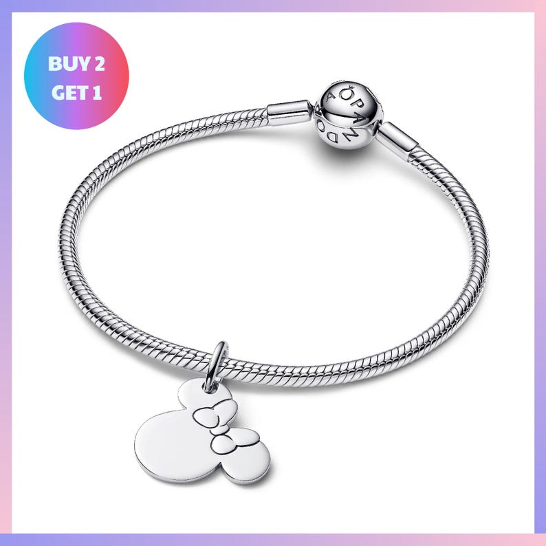 A silver bracelet with a charm featuring a Minnie Mouse design, and a text overlay that says "BUY 2 GET 1".