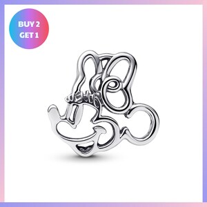 A silver-colored charm in the shape of a stylized letter "M" or a similar design, with a price tag indicating a "BUY 2 GET 1" offer.