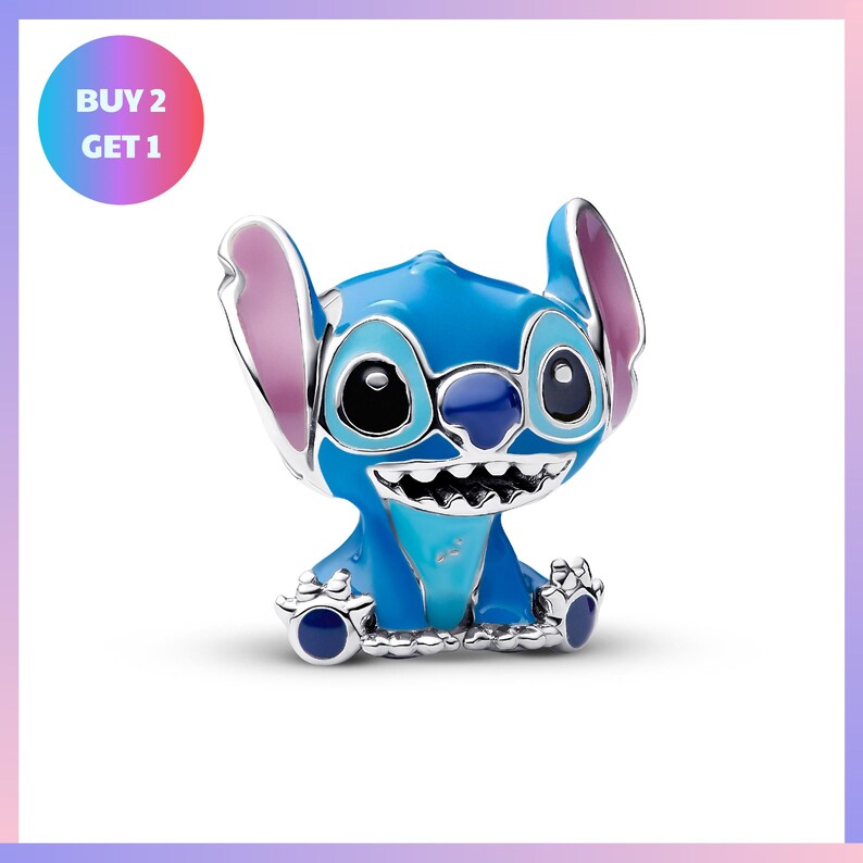 A blue plush toy resembling the character Stitch from the Disney movie "Lilo & Stitch". The toy has a smiling expression and is sitting on the ground.