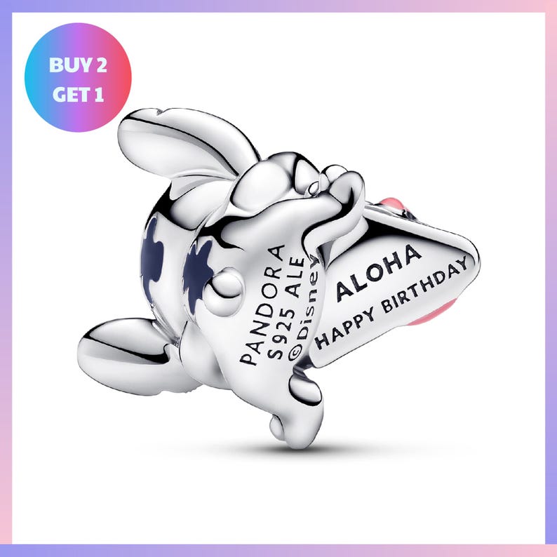 A silver charm in the shape of a cartoon character with a birthday message on it.