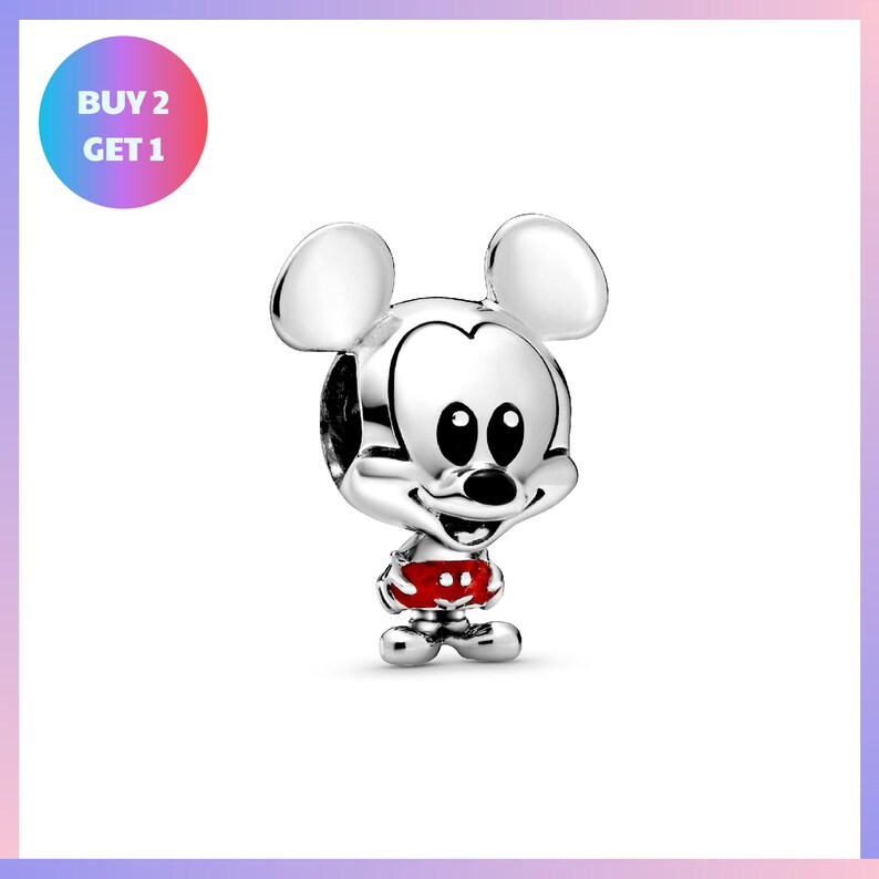 A silver charm in the shape of Mickey Mouse, wearing red pants, is displayed against a white background.