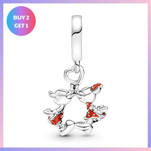A silver charm bracelet with a heart-shaped clasp and a playful design featuring cartoon-like figures.