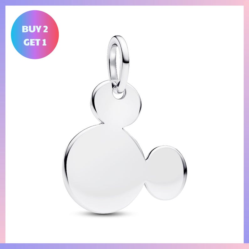 A silver charm in the shape of a Mickey Mouse ear, with the text "BUY 2 GET 1" displayed in the top left corner.