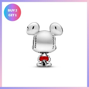 A silver charm in the shape of a cartoon character, with the word "Disney" written on it.