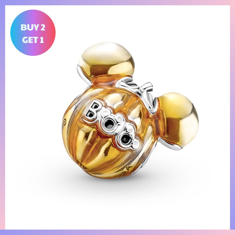 a gold-colored charm in the shape of a pair of ears, with the word "BOO" written on it.