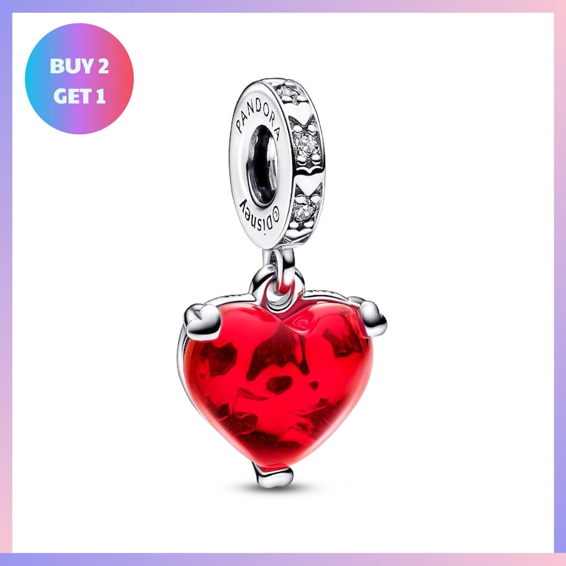 a red heart-shaped pendant with a silver charm attached to it, set against a white background.