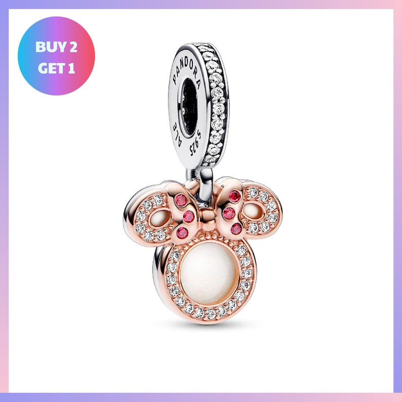 a pendant with a bow charm and gemstones, including a large gemstone in the center and smaller gemstones surrounding it.