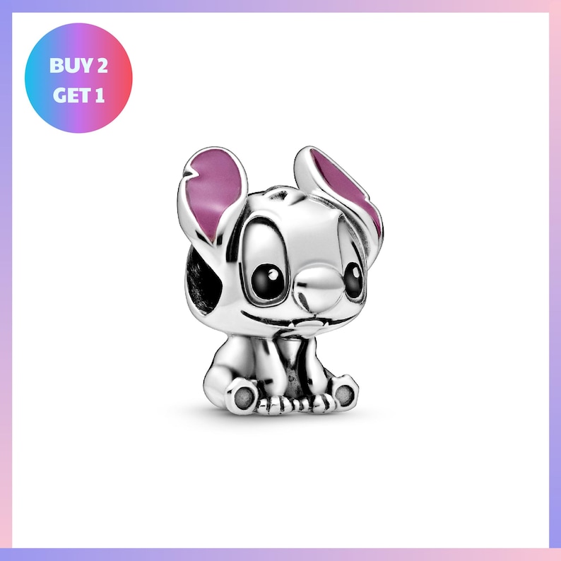 A silver charm in the shape of a cartoon character with large eyes and pink ears, sitting on its hind legs.