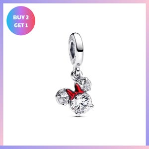 A silver charm bracelet with a red bow and three clear gemstones, including a large crystal and two smaller ones, hanging from a loop.