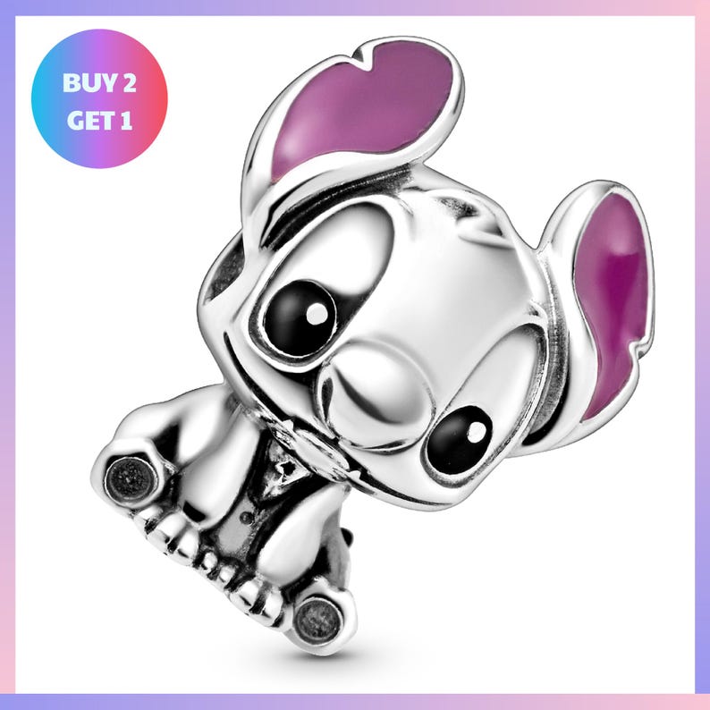A silver charm in the shape of a cartoon character with large eyes and pink ears, sitting on its hind legs.