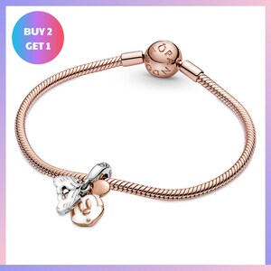 a pink and silver charm bracelet with a charm and a bead.